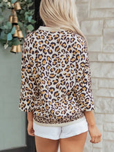 A woman wears a cream collar mixed leopard patchwork loose shirt with three quarter sleeves and leopard print
