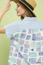 Women’s short-sleeved blouse shirt features mixed media geometric print in blue and green with striped collar and cuffs