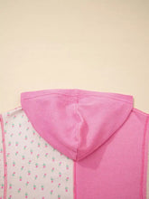 Pink waffle-knit hooded oversized pullover with floral patchwork side panel and slightly stretchy fabric care instructions included