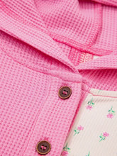 Pink waffle-knit cardigan with brown wooden buttons and floral patchwork inner lining, slightly stretchy with care instructions