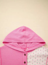 Pink waffle-knit hooded romper with floral patchwork panel and brown buttons made from slightly stretchy fabric with care instructions