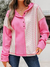 Pink and white floral patchwork hoodie with slightly stretchy waffle texture and care instructions on front panel detail