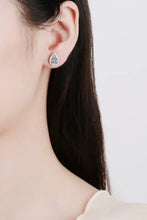 Silver moissanite teardrop stud earring with white stone halo on ear