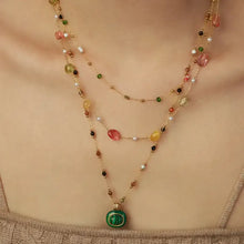Multi-layered bead necklace with green malachite pendant and gold accents