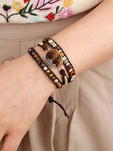 Multi-strand leather bracelet with tiger’s eye gemstone centerpiece