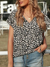 Black and white short sleeve leopard blouse with v-neckline in lightweight fabric for stylish casual wear