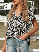 Black and white floral print short sleeve blouse with v-neckline styled as a short sleeve leopard blouse
