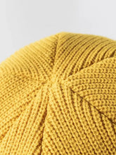 Close-up of mustard yellow distressed cuffed knit hat