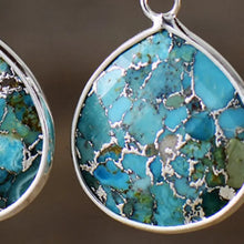 Two silver-framed turquoise natural stone teardrop earrings