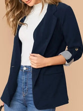Navy blue blazer featuring rolled sleeve length and pocket detail