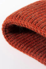 Close-up of rust-colored ribbed NewYork patch cuffed beanie
