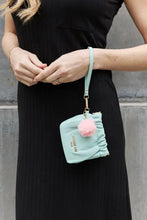 Nicole Lee USA faux leather pouch in light blue with pink pom-pom and gold-tone hardware