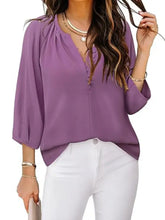 A soft lavender notched sleeve blouse with lightweight fabric v-neckline and three-quarter length sleeves
