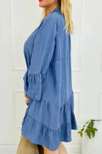 A blue denim dress with tiered ruffles and notched flare three-quarter length sleeves in flare sleeve denim style