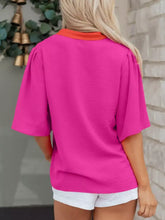 A vibrant fuchsia notched half sleeve blouse with orange collar made from soft textured fabric