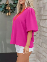 A vibrant fuchsia notched half sleeve blouse with contrasting orange and white v-neckline in lightweight fabric