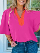 A vibrant pink notched half sleeve blouse with contrasting orange v-neck collar and puffed short sleeves