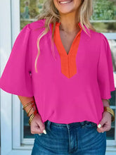 A vibrant pink notched half sleeve blouse with an orange v-neckline and puffed sleeves for stylish wear