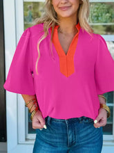 A vibrant pink notched half sleeve blouse with an orange v-neckline and bell sleeves for stylish wear