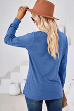 Blonde woman in notched long sleeve t-shirt, jeans, brown hat