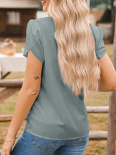 A soft sage green notched neckline petal sleeve blouse with puffed shoulders and a relaxed fit