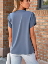 A soft slate blue notched petal sleeve blouse with puffed shoulders and a relaxed fit for elegant wear