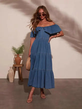 A woman wears a blue denim dress featuring off shoulder shoulder ruffle tiered sleeves and layered design