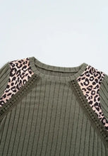 Olive green ribbed knit top with leopard shoulder accents and semi-sheer stretch