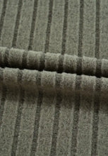 Striped wool scarf in muted gray and beige on olive green ribbed top