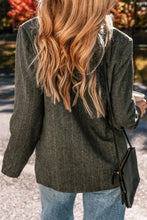 Olive green textured blazer with long sleeves, black buttons, and pocket details