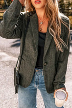 Olive green textured blazer with black buttons and pockets, paired with black tank top and blue jeans