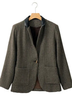 Olive green textured blazer with black lapel, pockets, and button details