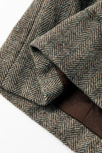 Olive green tweed herringbone blazer with brown leather trim and black buttons
