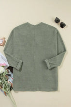 Sage green textured waffle knit sweater with rolled cuffs and button front