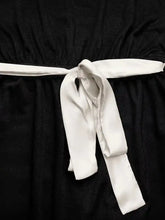 Sleek white satin bowknot at waist of black one-shoulder wide leg jumpsuit