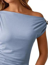 Light blue ribbed blouse with one-shoulder ruched design and decorative silver clasp on the shoulder