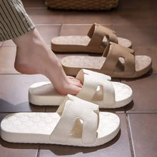 Person stepping into cream open toe platform slippers with H-strap