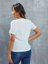 Woman in openwork short sleeve round neck top with moderate stretch and blue jeans