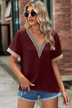 Woman in burgundy openwork V-neck short sleeve T-shirt with lace trim