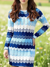 Woman in openwork wave pattern long sleeve sweater dress with navy, light blue, white stripes