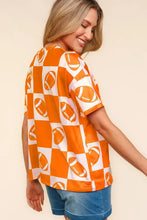 Woman in orange white football checkered print short sleeve t-shirt