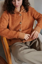 Orange long sleeve cardigan with collared neck button front and fuzzy boucle fabric