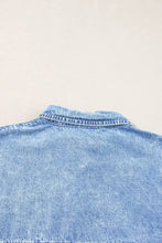A light-wash oversized button down denim shirt dress with classic collar and visible stitching as denim shirt dress