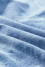 Soft faded blue denim fabric with textured weave and subtle fading patterns for oversized denim shirt dress