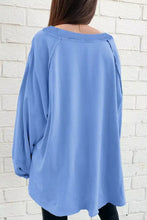 A soft light blue oversized washed crewneck sweatshirt with relaxed fit and care instructions for machine wash