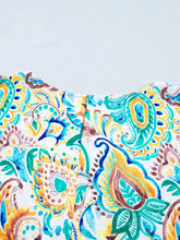 A paisley floral printed puff sleeve blouse in turquoise yellow and brown on white fabric with off the shoulder design