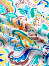 Paisley floral printed puff sleeve blouse with vibrant teal orange blue and brown fabric on white background
