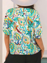 A vibrant paisley floral printed puff sleeve blouse in teal yellow and brown on white with short sleeves
