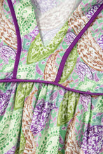 Paisley print half puff sleeve blouse in vibrant green and purple with v-neckline and bold purple trim accents