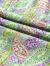 A paisley print half puff sleeve blouse with vibrant green purple and brown fabric featuring intricate floral designs